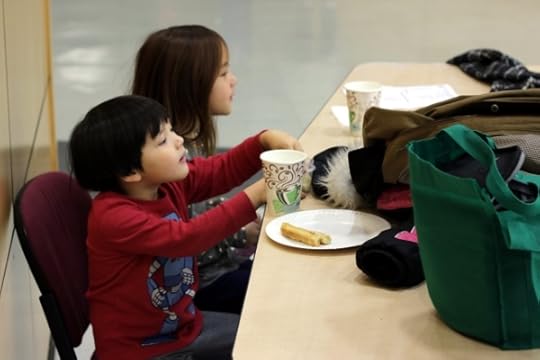 SteelyKid and The Pip eating dinner at a basketball game.