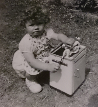 photo of toddler Debbie with toy washing machine