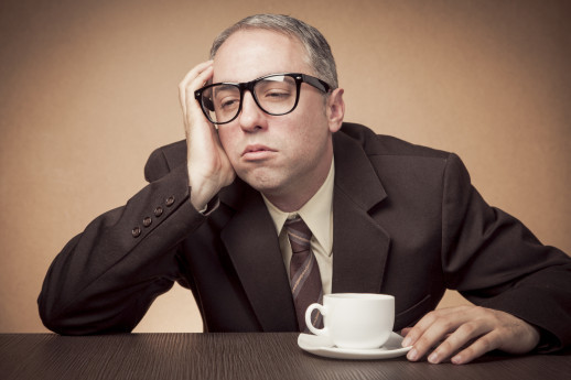 Nerdy businessman having problems staying awake, in need for coffee