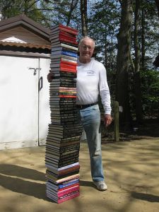 Roy F. Chandler standing next to a stack of the books he has written. Photo by Katherine R. Chandler/29 April 2009