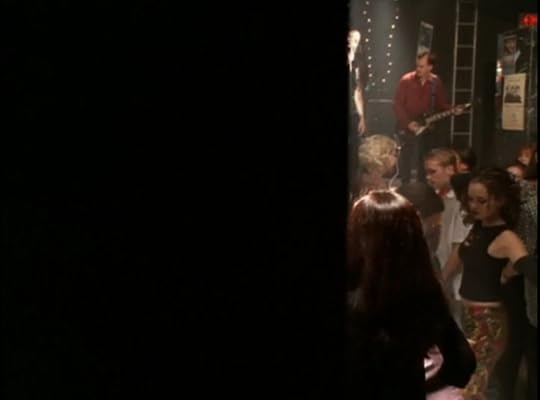 As the scene fades in from right to left, we see people dancing. The first face we see as the black wipe goes across the screen is Faith.