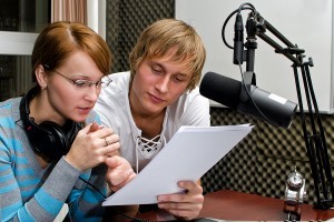 Colleagues Examine Broadcast List In Studio