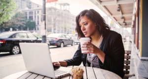 A shot of an African American businesswoman working on her laptop at an outdoor cafe