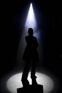 A silhouette of a person under an entertaiment light.