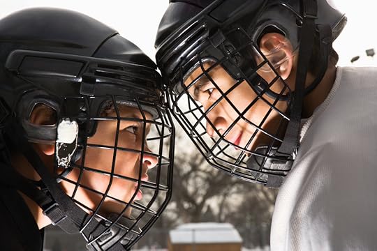 Two ice hockey players in uniform facing off trying to intimidate eachother.