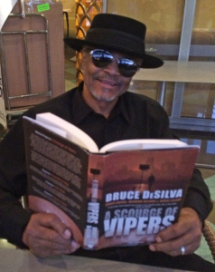 Bluesman Theodis Ealey reading Bruce DeSilva's crime novel, 