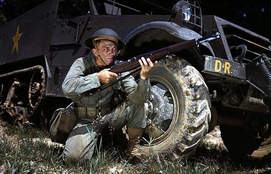 Infantryman in herringbone twill fatigues, kneeling in front of M3 Half-track, holds and sights an M1 Garand rifle. Fort Knox, Kentucky, June 1942. (Library of Congress)