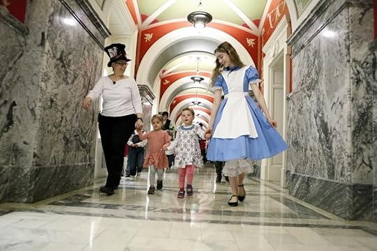 The Mad Hatter and Alice lead children on a parade through the Library following a storytime reading of 
