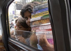 Indian kids selling pirated books to car passengers
