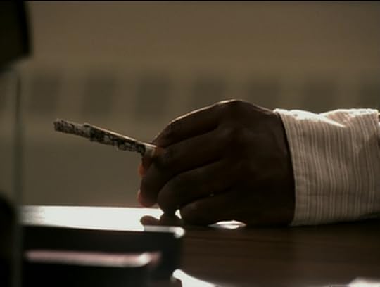 Mr. Pratt's hand, holding a cigarette that's burned all the way down.