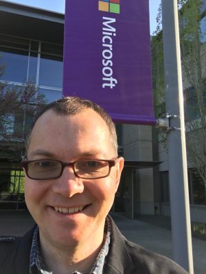 Picture of Tom in front of a Microsoft Banner