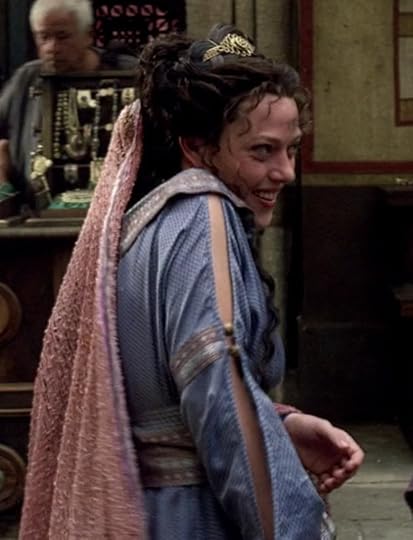 Jocasta is wearing a purple dress with slashed sleeves banded at the elbow with ribbon and buttons. She has a little tiara in her hair, with a long mauve veil of some kind of knit cloth with a lot of rustic pilling.