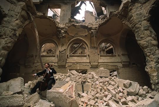 In an act of cultural genocide, Bosnian Serb forces directed led by Karadžić destroyed Sarajevo’s National and University Library (aka Vijećnica) during the 1425-day Siege of Sarajevo. The cello player in this 1992 photograph is Vedran Smailović, a Sarajevan who often performed at funerals during the lengthy siege. (Local musician Vedran Smailović plays in the partially destroyed Bosnia National Library during the war in 1992 in Sarajevo. Photo by Mikhail Evstafiev. CC BY-SA 3.0 via Wikimedia Commons.)