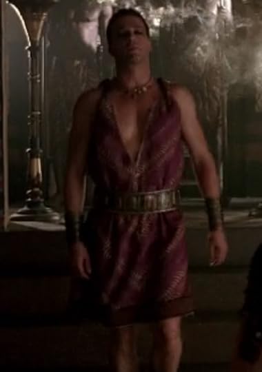 Antony is wearing a very short purple dress with a wide belt around it. The top is a super deep-v neck and sleeveless.