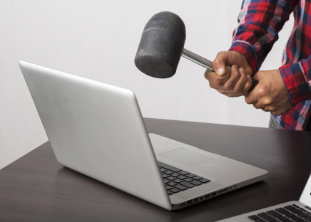 Angry man crashing laptop