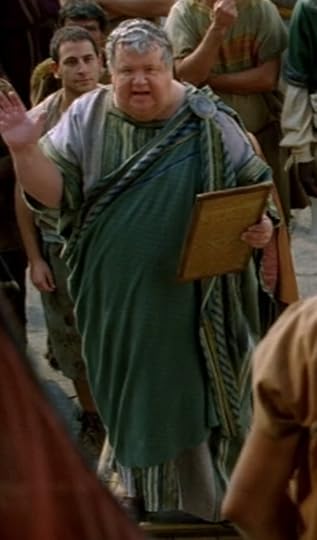 For the guy who's basically the Dan Rather of Rome, the Newsreader's clothes are sewn pretty rough, but the fabric is neat. It's all different shades of blue and green and white and black woven together, with an awesome bronze pin about the size of a bread plate at his shoulder.