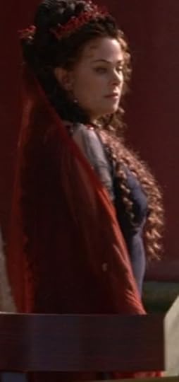 Atia's dress is really dark blue and tight and silky, with sheer sleeves. She's got a red scarf thing that's very gossamer and sheer, as well. Her hair is totally huge, like she's a Roman Marie Antoinette.