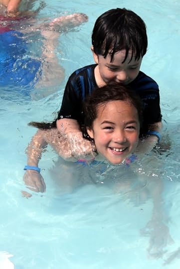SteelyKid giving The Pip a piggyback ride in the wading pool on the ship.