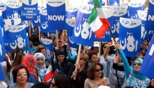 KUWAIT CITY, KUWAIT: Kuwaiti women demonstrate in front of the parliament building in Kuwait City to demand their political rights, 07 March 2005. As a battle has raged in the Gulf emirate over political rights for its disenfranchised women, female activists and their liberal supporters staged the rally the morning the parliament was scheduled to discuss a government request to speed up the debate on a women's rights bill. The bill, approved by the cabinet last May and opposed by Islamic hardliners, calls for amending article one of the 1962 electoral law which limits voting and candidacy to male citizens whereas the constitution stipulates gender equality. AFP PHOTO/YASSER AL-ZAYYAT (Photo credit should read YASSER AL-ZAYYAT/AFP/Getty Images)