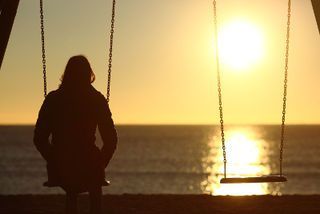 Person on swingset, trying to forget the past
