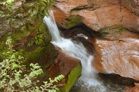 Close-up look at how the force of the water wears away the rock over houndreds of years.