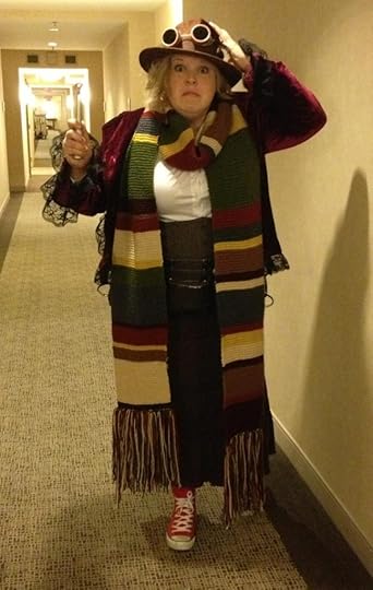 Me, dressed in a velvet frock coat, long 4th Doctor scarf, a tweed corset, hat and goggles, and red converse sneakers. I'm posing in a hotel hallway, with my best impression of Tom Baker's worried face.