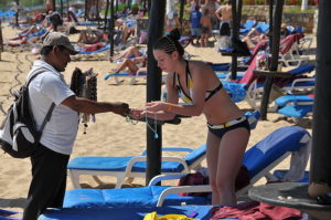 woman on a beach buying jewelry - Yellen Rate Hike