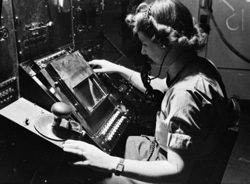 WAAF radar operator Denise Miley plotting aircraft on the CRT (cathode ray tube) of an RF7 Receiver in the Receiver Room at Bawdsey Chain Home Station (Imperial War Museum)