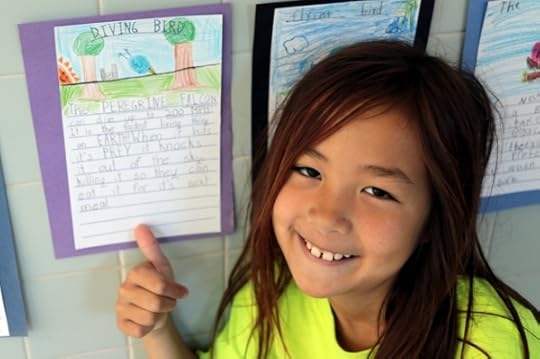 SteelyKid with her hand-written report on the peregrine falcon.