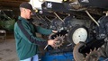 A farmer repairs his planting machine.