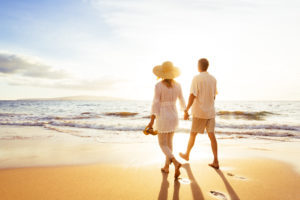 Happy Romantic Middle Aged Couple Enjoying Beautiful Sunset Walk on the Beach. Travel Vacation Retirement Lifestyle Concept