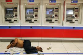 A man sleeps in front of ATM machines in Paulista Avenue in central Sao Paulo June 8, 2014. REUTERS/Damir Sagolj (BRAZIL - Tags: SPORT SOCCER WORLD CUP) - RTR3SSMR