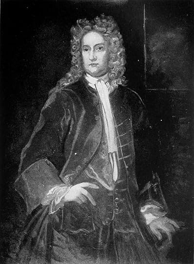 Grayscale image of a man in allonge wig, waiscoat and coat standing with hand on hip