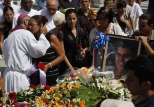 Ofelia Acevedo, wife of Oswaldo Paya, one of Cuba's best-known dissidents, is comforted by a priest near the tomb of her husband after his burial in Havana July 24, 2012. Paya, leader of the Christian Liberation Movement, died on Sunday in a car crash, government and opposition sources said. Another dissident died in the crash, and a Spaniard and Swede were injured, after the car left the road and hit a tree, government officials told Reuters. REUTERS/Stringer (CUBA - Tags: POLITICS OBITUARY) - RTR359TA