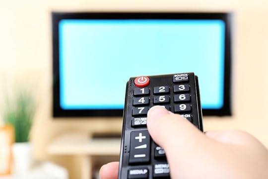 38078016 - watching tv and using remote controller