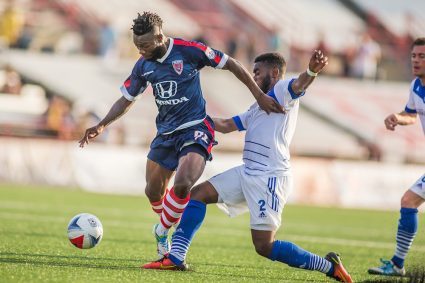 Indy's Omar Gordon fights off a challenge from FCE's Allan Zebie PHOTO: TREVOR RUSZKOWSKI