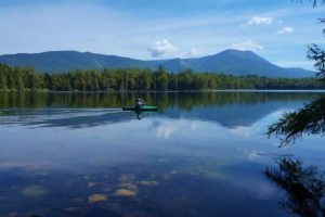 Liz kayaks on Daicey Pond with Katahdin in the background. 