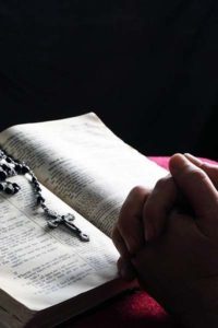 returning_prayingwithbible_wikimediacommons_publicdomain20150808