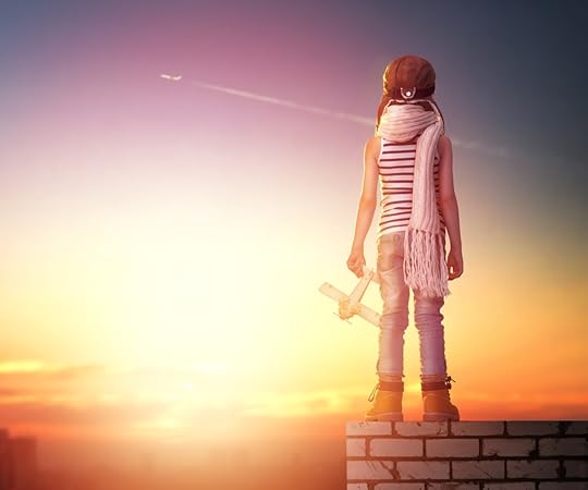 Child dressed as a pilot staring at a plane