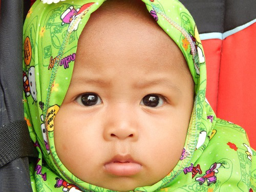 Baby wearing Muslim head scarf.