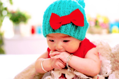 Baby gnawing her fingers.