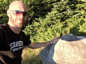 Sitting beside one of he stones with a poem etched into it.