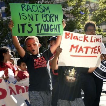 Kaden Pagani, 8, left, and his brother Kingston, 6, carry signs as they march down Broadway toward Frank Ozawa Plaza during a Black Lives Matters protest in Oakland on Thursday, July 21, 2016. Image by Michael Short.