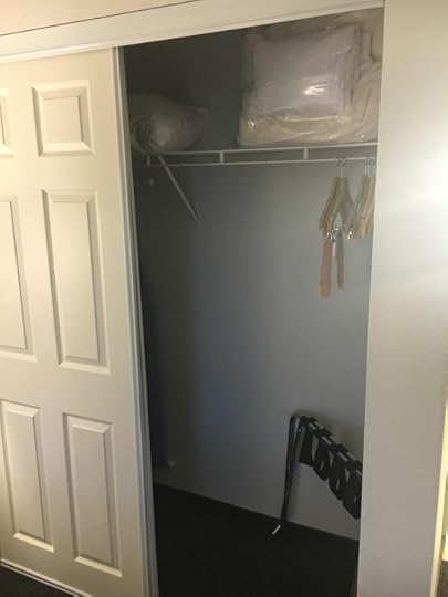 Closet with rack, hangers, extra pillows & blankets