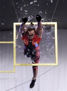 A member of the Streb Extreme Action Company breaks through a framed panel of mock glass during ground breaking ceremonies for a new Whitney Museum, in New York, Tuesday, May 24, 2011. The nine-story, metal-clad building, which will include a series of asymmetrical rooftops for outdoor exhibitions facing the High Line and the nearby Hudson River, is designed by Italian architect Renzo Piano and will nearly double the museum's current gallery space. (AP Photo/Richard Drew)
