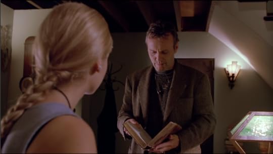 Now we're in Giles's apartment, looking over Buffy's shoulder (so it's a good shot of her Lara Croft braid) and Giles is wearing a tweed jacket now, but he still has the stubble and he's chewing on the end of one of the ear things of his glasses.