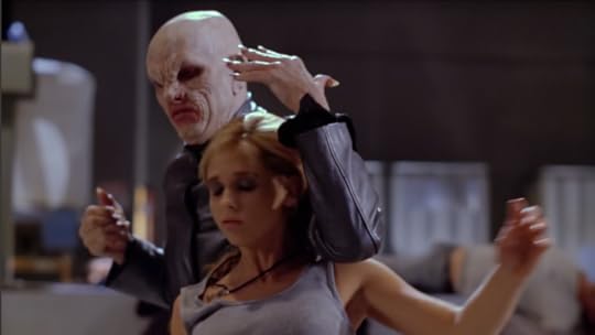 The Master is standing behind Buffy. His arm is on her shoulder, and he's just broken her neck, so she stares deadly off at nothing.
