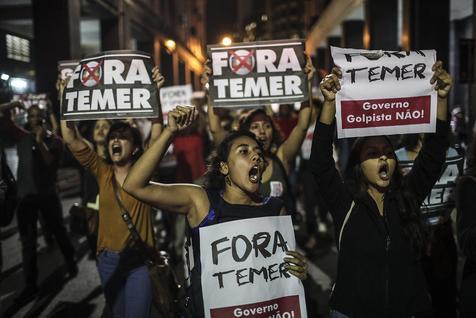 epa05517854 Demonstrators shout slogans during a protest held to show opposition to the Brazilian Senate's decision to remove President Dilma Rousseff from office over budget irregularities, in Rio de Janeiro, Brazil, 31 August 2016. Brazil's Senate voted 61-20 on Wednesday to remove President Dilma Rousseff from office. The decision means that Michel Temer, who became interim president on 12 May, will serve the remainder of Rousseff's 2015-2019 term. The placards held by the protesters read 'Temer out'. EPA/ANTONIO LACERDA