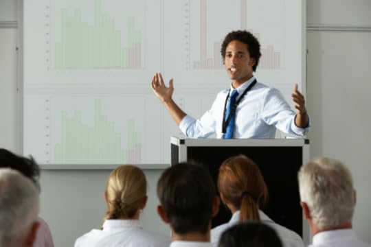 Speaker at a podium angling his body to the audience.