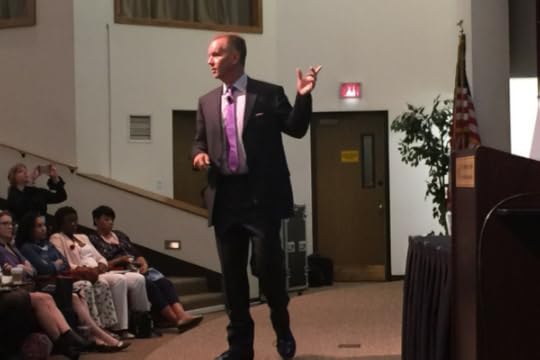 Public speaker walking and talking to an audience at an angle.